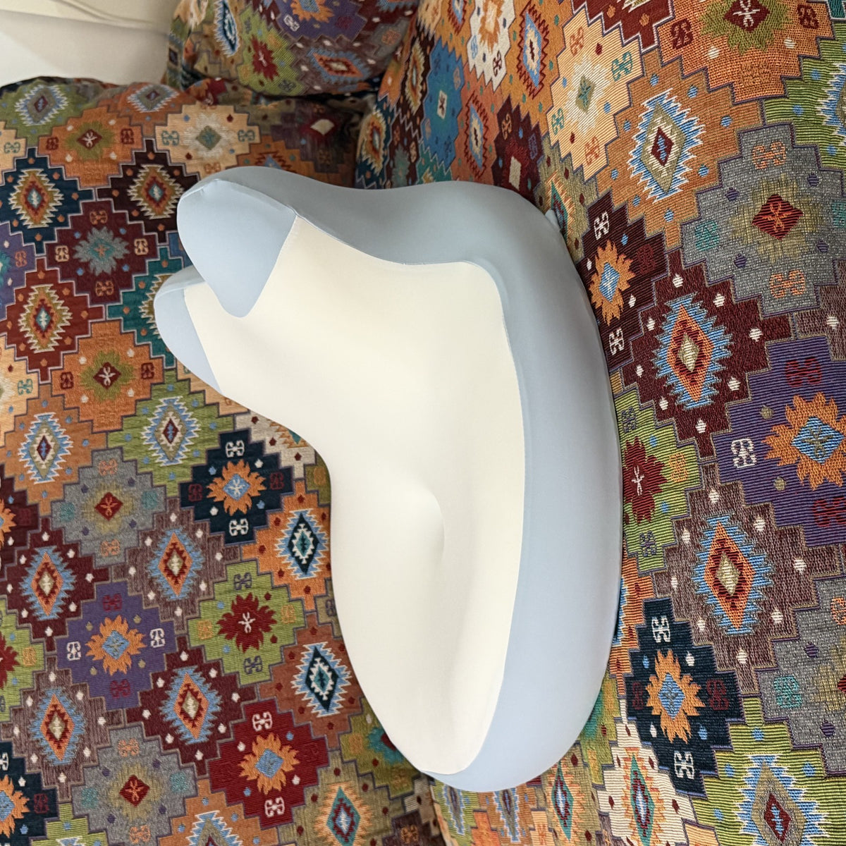 Blue and white CozyEnjoy Scroll Pillow resting on a patterned sofa with no person present