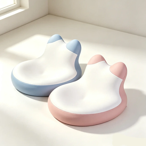 Two cat-shaped ergonomic office chair backrests, one in light blue and one in light pink, shown on a clean white surface with soft window light.
